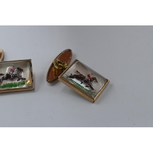 386 - A pair of cufflinks with enamelled decorations of racehorses (2).