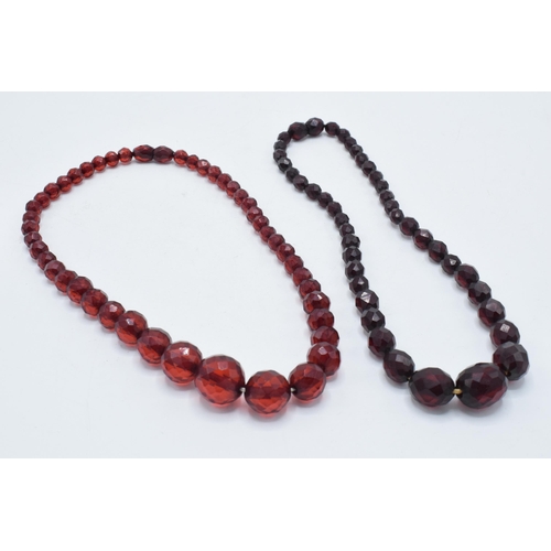 387 - A pair of vintage bakelite cherry amber (or similar) graduated necklaces with faceted beads, each ap... 