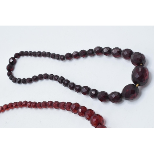 387 - A pair of vintage bakelite cherry amber (or similar) graduated necklaces with faceted beads, each ap... 