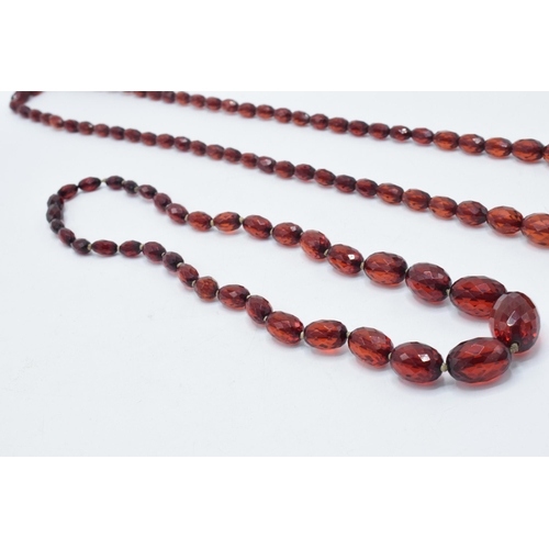 388 - A pair of vintage bakelite cherry amber (or similar) graduated necklaces with faceted beads, longest... 