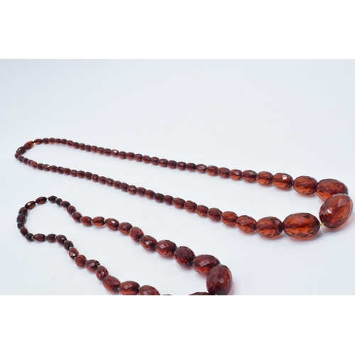 388 - A pair of vintage bakelite cherry amber (or similar) graduated necklaces with faceted beads, longest... 