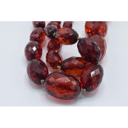 388 - A pair of vintage bakelite cherry amber (or similar) graduated necklaces with faceted beads, longest... 