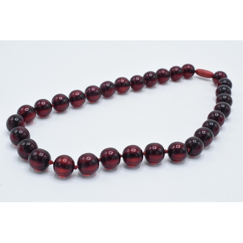 389 - A single row of bakelite cherry amber (or similar) necklace, 43.7 grams, 47cm long.