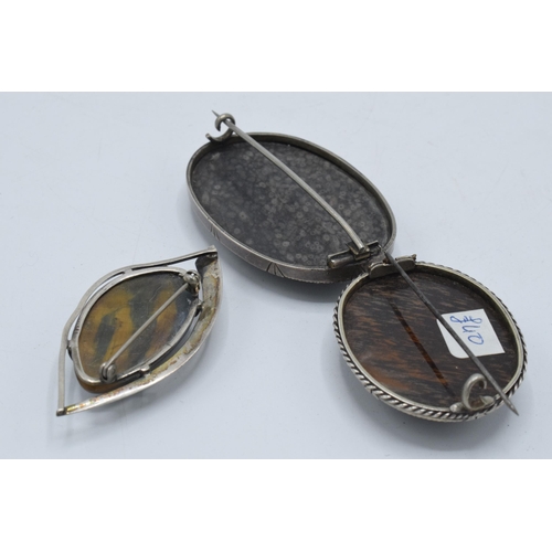 398 - A trio of silver framed brooches to include a Georgian or later fossil brooch together with 2 others... 