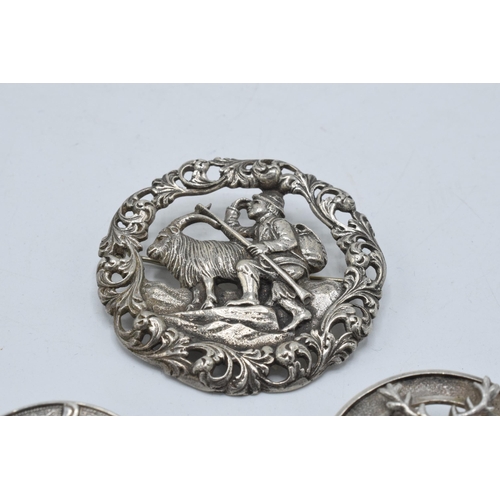 399 - A large silver 830s Scandinavian brooch with traditional scenes together with a Scottish deer brooch... 