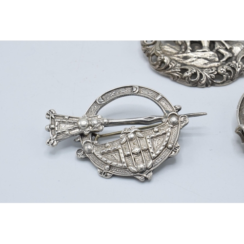 399 - A large silver 830s Scandinavian brooch with traditional scenes together with a Scottish deer brooch... 