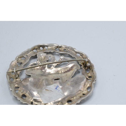 399 - A large silver 830s Scandinavian brooch with traditional scenes together with a Scottish deer brooch... 