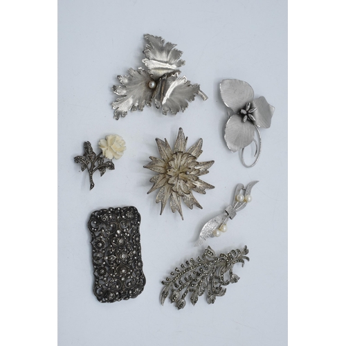 401 - A collection of silver brooches to mainly consist of floral designs to include marcasite and filigre... 