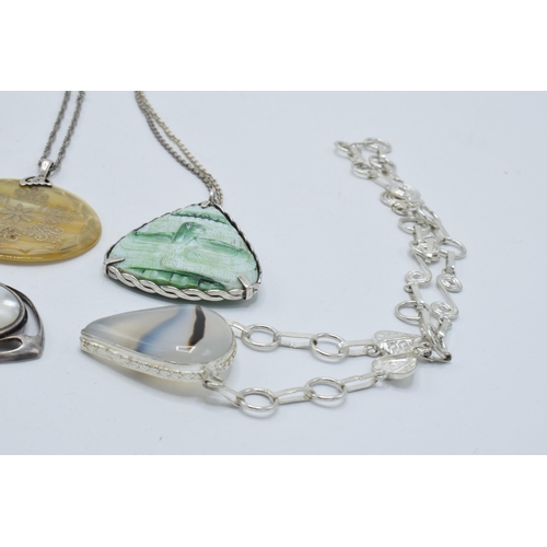 402 - A collection of silver necklaces with large pendants made from various materials (4).