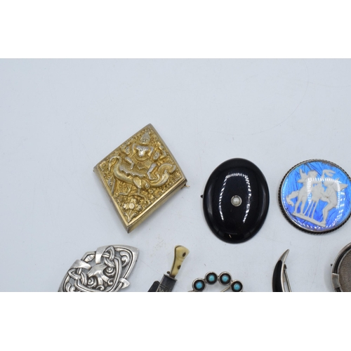 404 - A collection of silver brooches to include a silver gilt Indian brooch, a Scandinavian examples and ... 