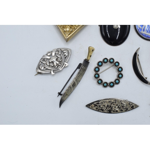 404 - A collection of silver brooches to include a silver gilt Indian brooch, a Scandinavian examples and ... 