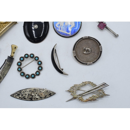 404 - A collection of silver brooches to include a silver gilt Indian brooch, a Scandinavian examples and ... 