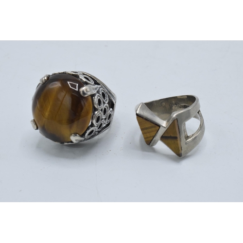 405 - Silver chunky ornate ring set with large tiger's eye together with a modernist similar example (2).