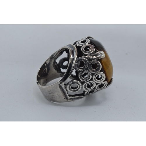 405 - Silver chunky ornate ring set with large tiger's eye together with a modernist similar example (2).