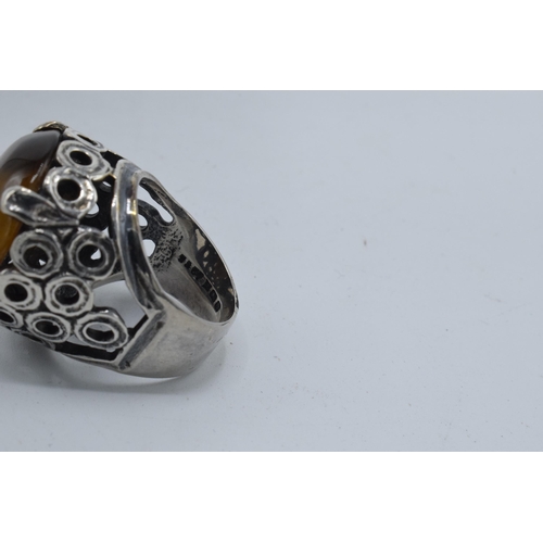 405 - Silver chunky ornate ring set with large tiger's eye together with a modernist similar example (2).