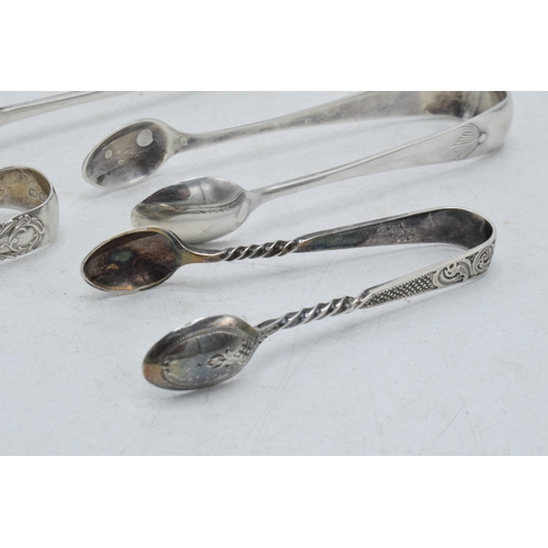 71 - A collection of hallmarked silver sugar tongs to include a plain pair and others with ornate designs... 