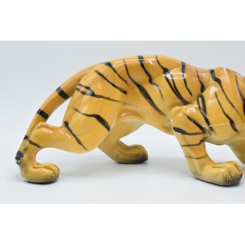 133 - Mid 20th century chalk ware model of a crouching tiger, RD 896256, 35cm long.