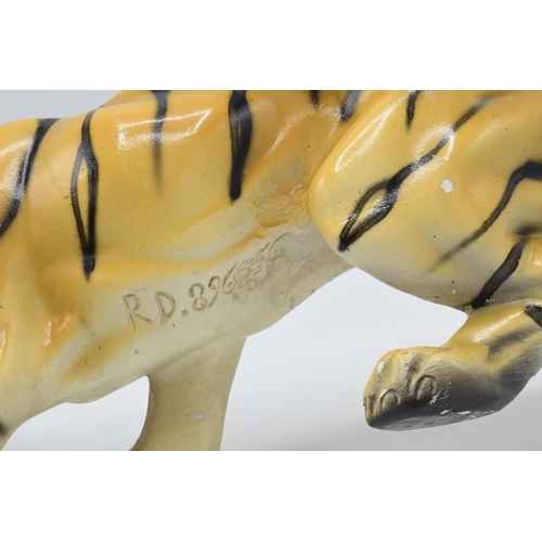 133 - Mid 20th century chalk ware model of a crouching tiger, RD 896256, 35cm long.