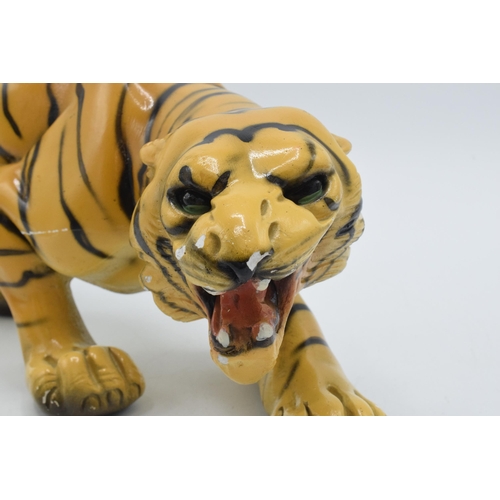 133 - Mid 20th century chalk ware model of a crouching tiger, RD 896256, 35cm long.