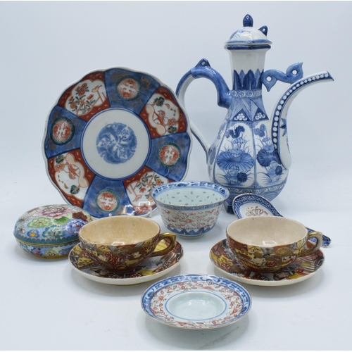 93 - A collection of oriental ceramics to include a large ewer with lid, cups and saucers, an Imari charg... 