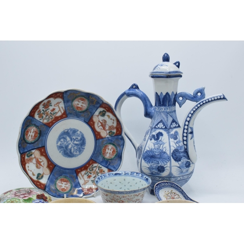 93 - A collection of oriental ceramics to include a large ewer with lid, cups and saucers, an Imari charg... 