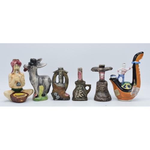 82 - A collection of novelty decanters to include a Drioli snake charmer, a Donkey,  stone effect bottles... 