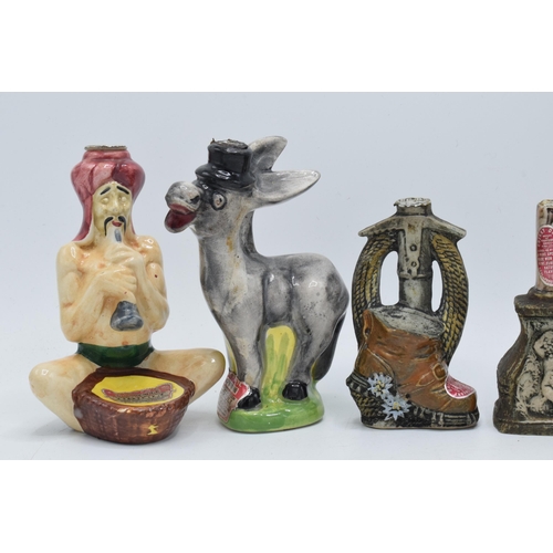 82 - A collection of novelty decanters to include a Drioli snake charmer, a Donkey,  stone effect bottles... 