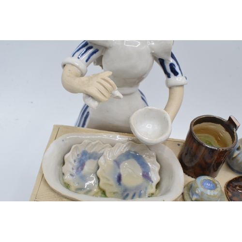 84 - A collection of Laura Dunn ceramic cooking figures to include a girl mixing, a couple with bread and... 