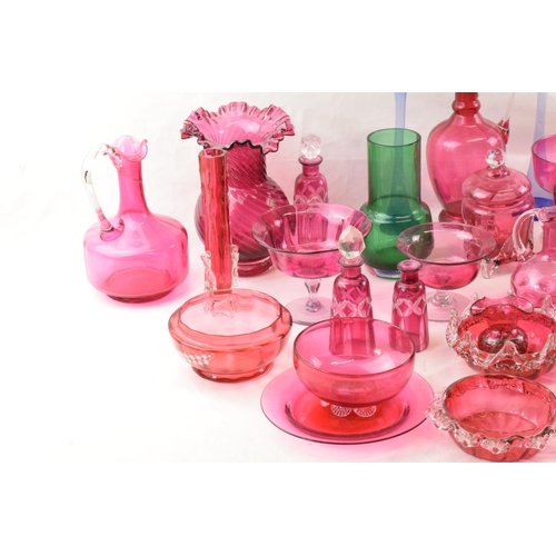 154 - A good collection of cranberry glass ware to include decanters, bowls, a Jack in the Pulpit hanging ... 