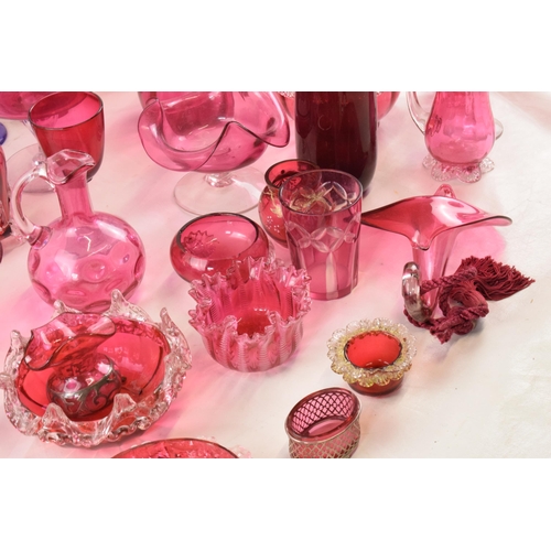 154 - A good collection of cranberry glass ware to include decanters, bowls, a Jack in the Pulpit hanging ... 