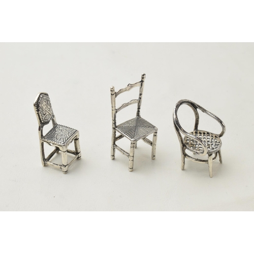 168O - A trio of miniature silver chairs, 13.1 grams, tallest 35mm (3).