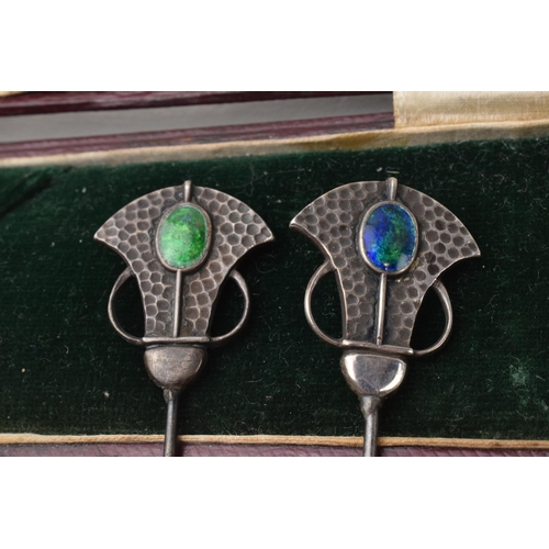 168Q - Cased pair of Art Nouveau hat pins with enamelled decoration and hammered Liberty style elements, lo... 