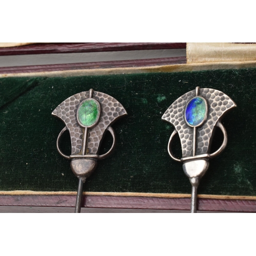 168Q - Cased pair of Art Nouveau hat pins with enamelled decoration and hammered Liberty style elements, lo... 