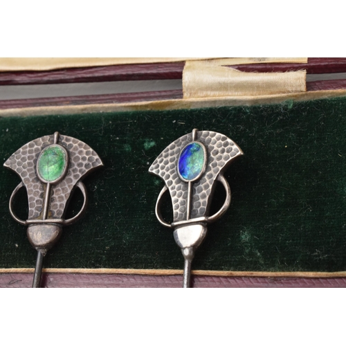 168Q - Cased pair of Art Nouveau hat pins with enamelled decoration and hammered Liberty style elements, lo... 