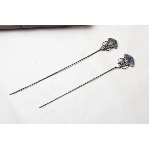 168Q - Cased pair of Art Nouveau hat pins with enamelled decoration and hammered Liberty style elements, lo... 