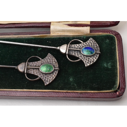 168Q - Cased pair of Art Nouveau hat pins with enamelled decoration and hammered Liberty style elements, lo... 