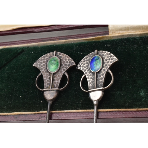 168Q - Cased pair of Art Nouveau hat pins with enamelled decoration and hammered Liberty style elements, lo... 