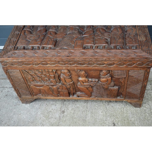 503 - Nigerian hard wood carved coffer / blanket box with carved figural decoration amongst traditional sc... 