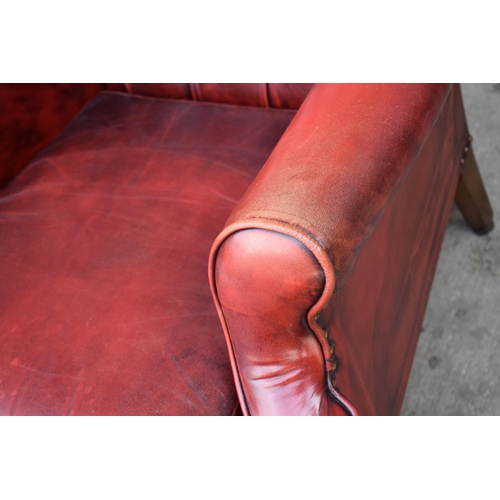 505 - Queen Anne revival chesterfield wingback armchair, in red leather with button back, raised on front ... 