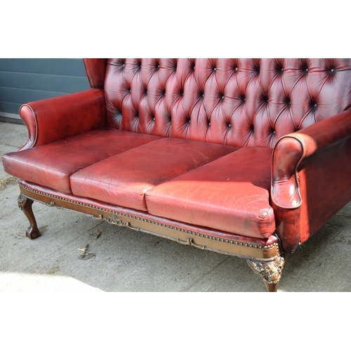 506 - Queen Anne revival chesterfield wingback three seater sofa, with high back, in red leather with butt... 