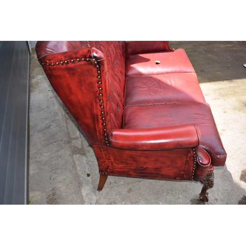 506 - Queen Anne revival chesterfield wingback three seater sofa, with high back, in red leather with butt... 