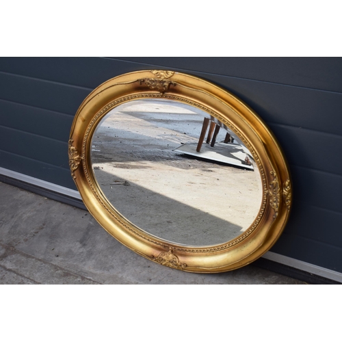 507 - Reproduction oval gilt mirror with bevel edged mirror, 86x66cm.