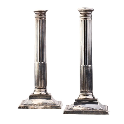 293 - A pair of 26cm tall silver Corinthian column candlesticks, Birmingham 1908, with loaded bases, gross... 