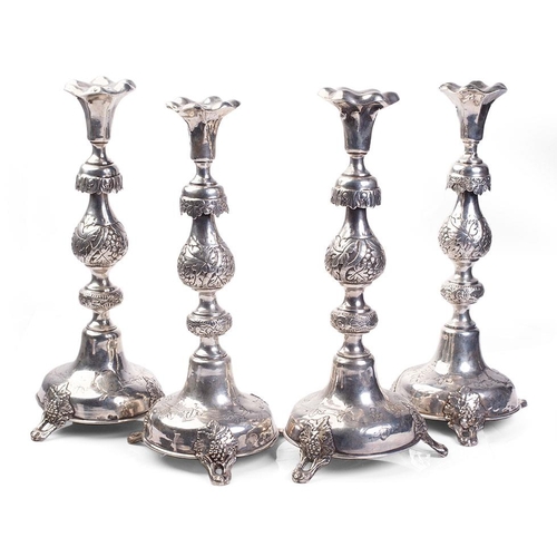 319 - A quartet of Russian silver ornate tall candlesticks, 34cm tall, with leaf and berry pattern decorat... 