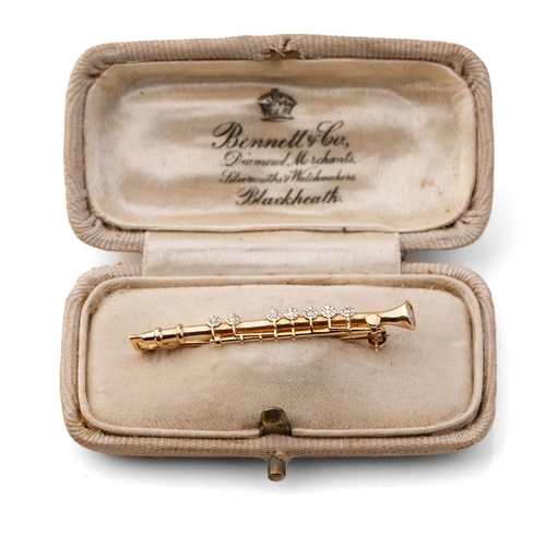 397 - 9ct gold diamond set bar brooch in the form of a clarinet, 2.5 grams, 4.5cm wide.