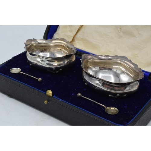 284 - A cased pair of hallmarked silver salts with spoons, Chester 1920, 79.4 grams.