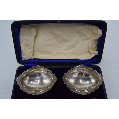 284 - A cased pair of hallmarked silver salts with spoons, Chester 1920, 79.4 grams.