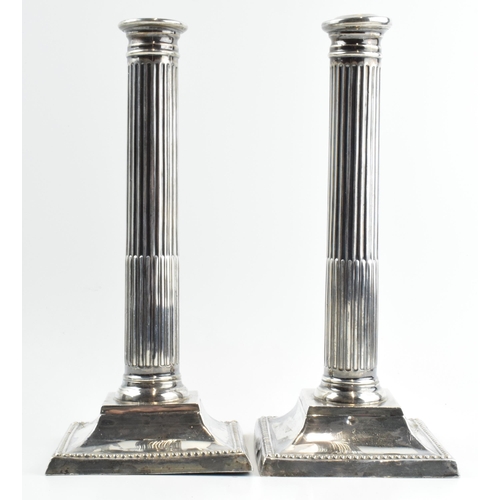 293 - A pair of 26cm tall silver Corinthian column candlesticks, Birmingham 1908, with loaded bases, gross... 