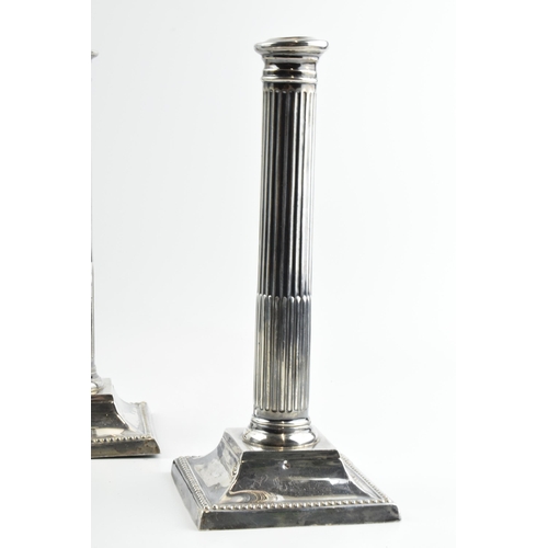 293 - A pair of 26cm tall silver Corinthian column candlesticks, Birmingham 1908, with loaded bases, gross... 