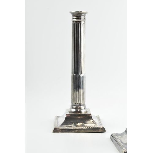 293 - A pair of 26cm tall silver Corinthian column candlesticks, Birmingham 1908, with loaded bases, gross... 